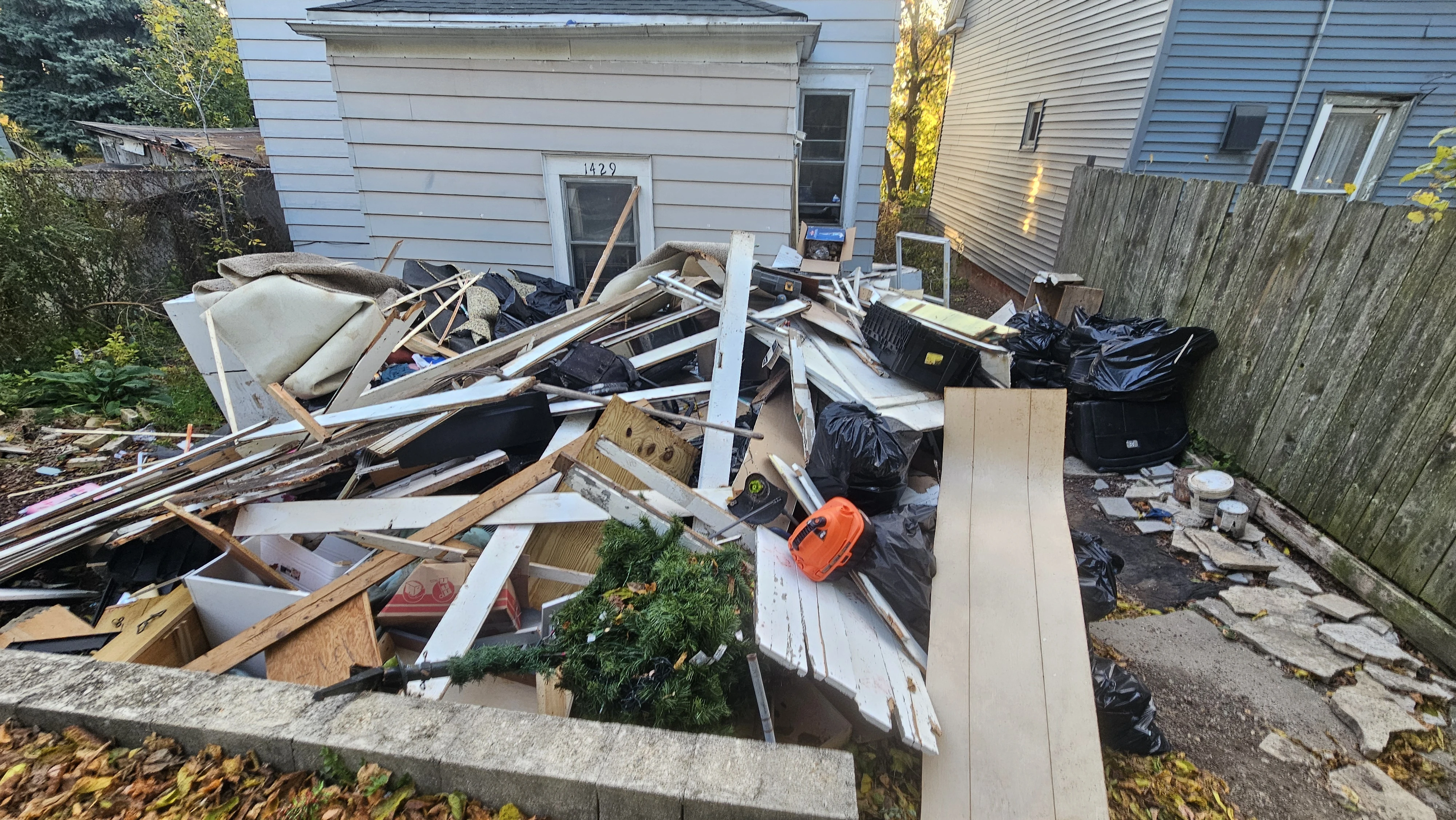 Before the Milwaukee outdoor cleanout: carpet, wood pieces and bagged debris
