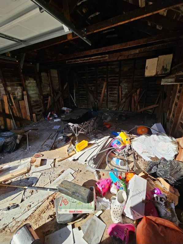 Loose belongings, bags and material pieces covering the floor before a Milwaukee garage cleanout
